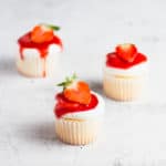 close up photo of three strawberry shortcake cupcakes