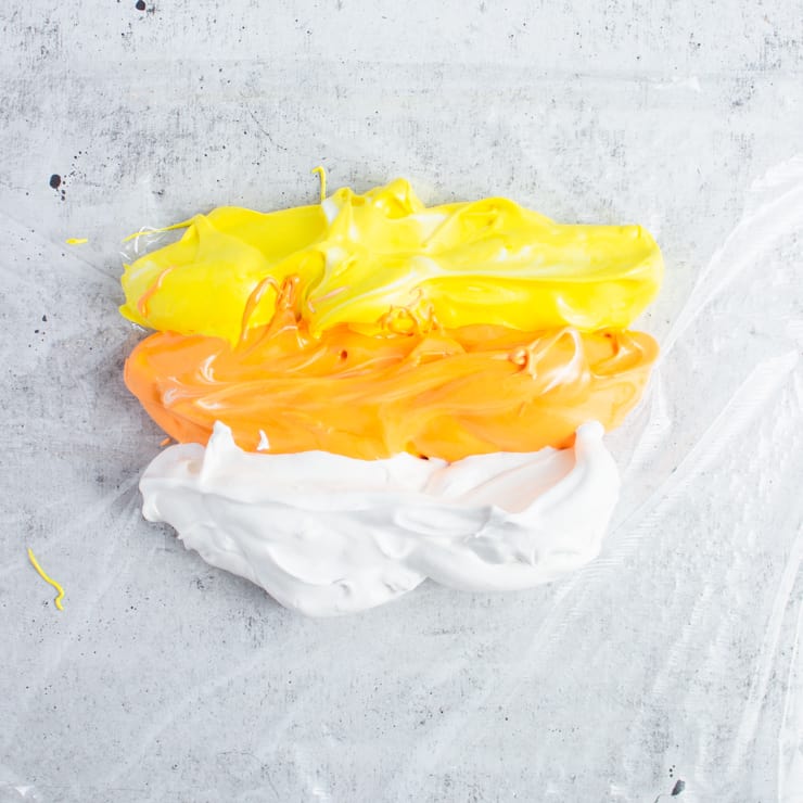orange, yellow and white meringue on a piece of cling wrap