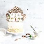 cake with gold sprinkles and gingerbread cookies on top