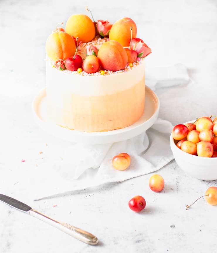 peach cake next to a bowl of cherries