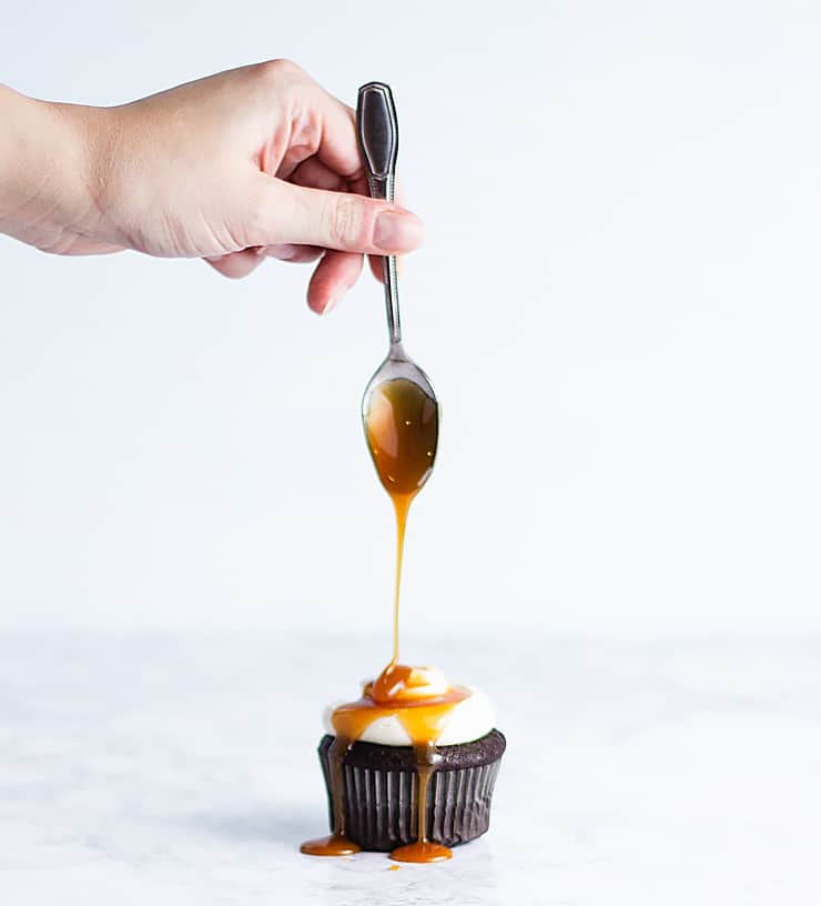 drizzling caramel onto cupcakes