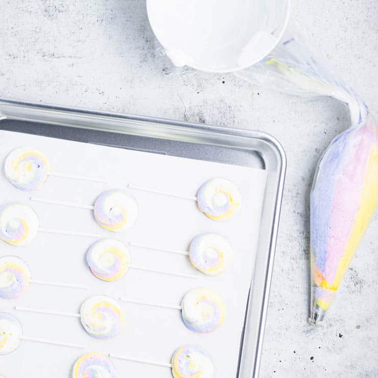 meringue pops piped onto a baking sheet