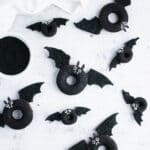 bat doughnuts on a gray background with a bowl of black sanding sugar.