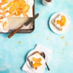 Sheet cake with whipped cream and peaches sliced and served on two small plates