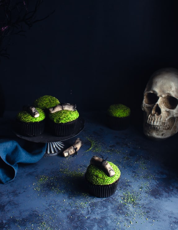 green cupcakes with fondant fingers against a dark backdrop