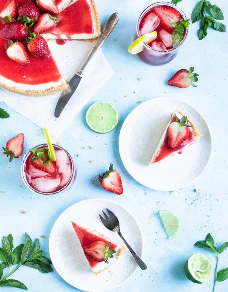 slices of cheesecake interspersed with margaritas, slices of lime and strawberries and mint