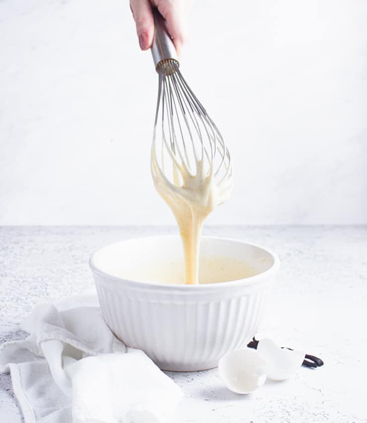 whisk with cake batter dripping off of it