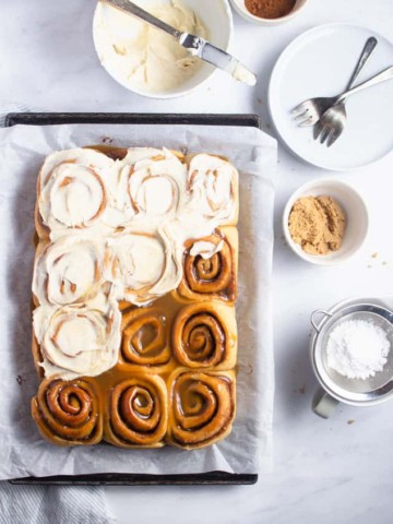flat lay photo of half frosted cinnamon rolls