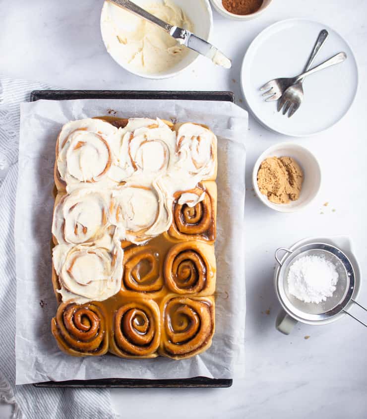 flat lay photo of half frosted cinnamon rolls