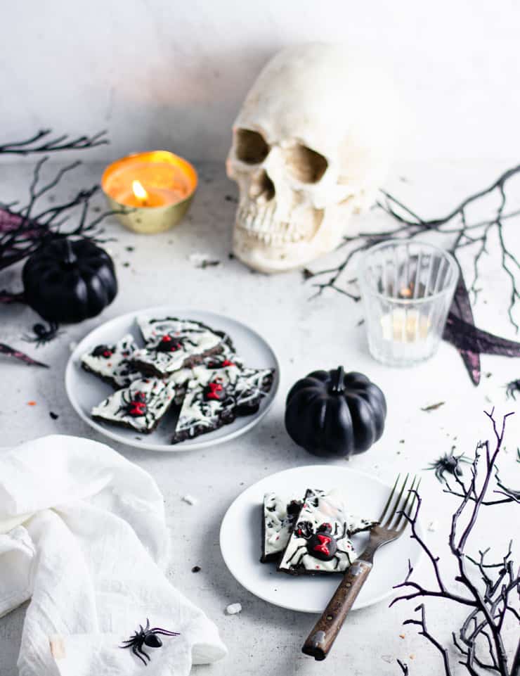 spider candy bark with skull and black pumpkins in the background