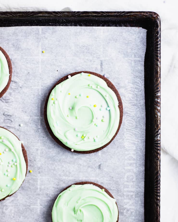 close up of chocolate sugar cookies with light green frosting