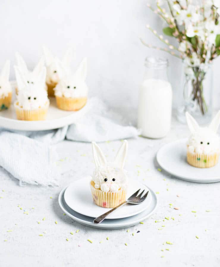 easter bunny cupcake on a plate with other cupcakes in the background