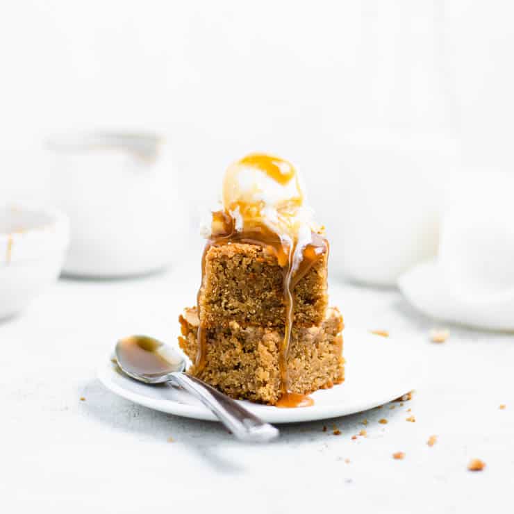 stacked peanut butter blondies with a scoop of ice cream and caramel sauce