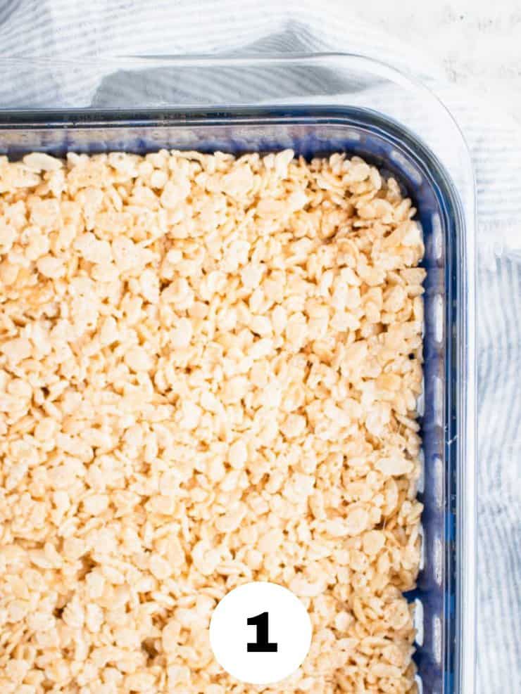rice krispie treats in a glass casserole dish with blue silicone webbing around the outside.