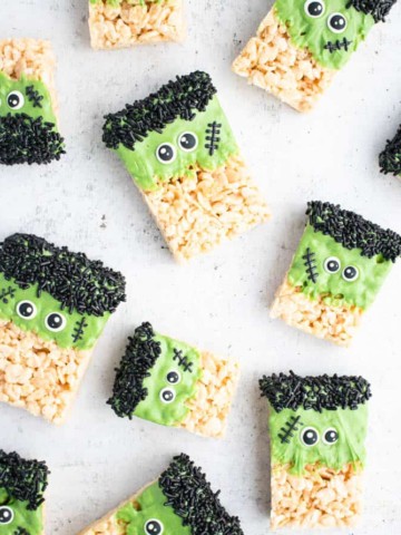 Overhead view of multiple frankenstein rice krispie treats on a white background.