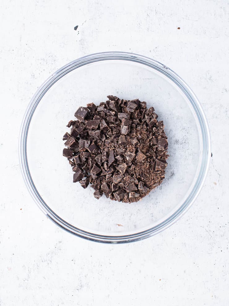 Finely chopped up chocolate in a clear bowl.