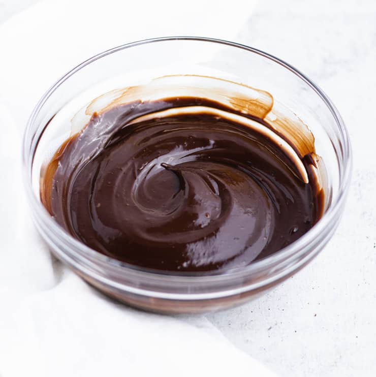 Chocolate ganache in a clear bowl cooled so that it holds a swirl.